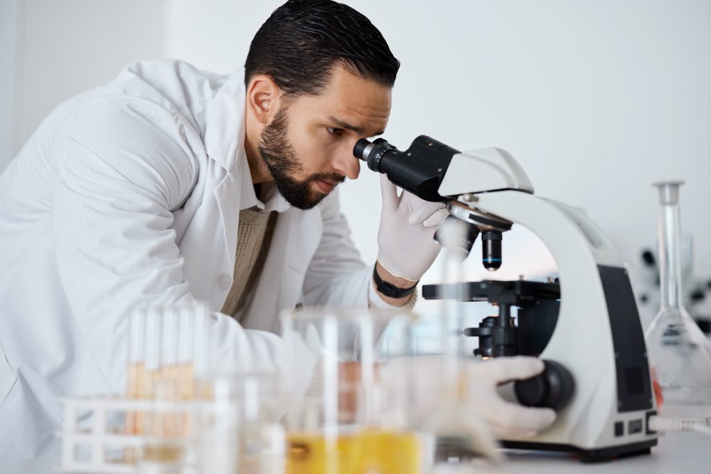 Scientist examining molecular peptides through a microscope signaling cellular repair and regeneration.